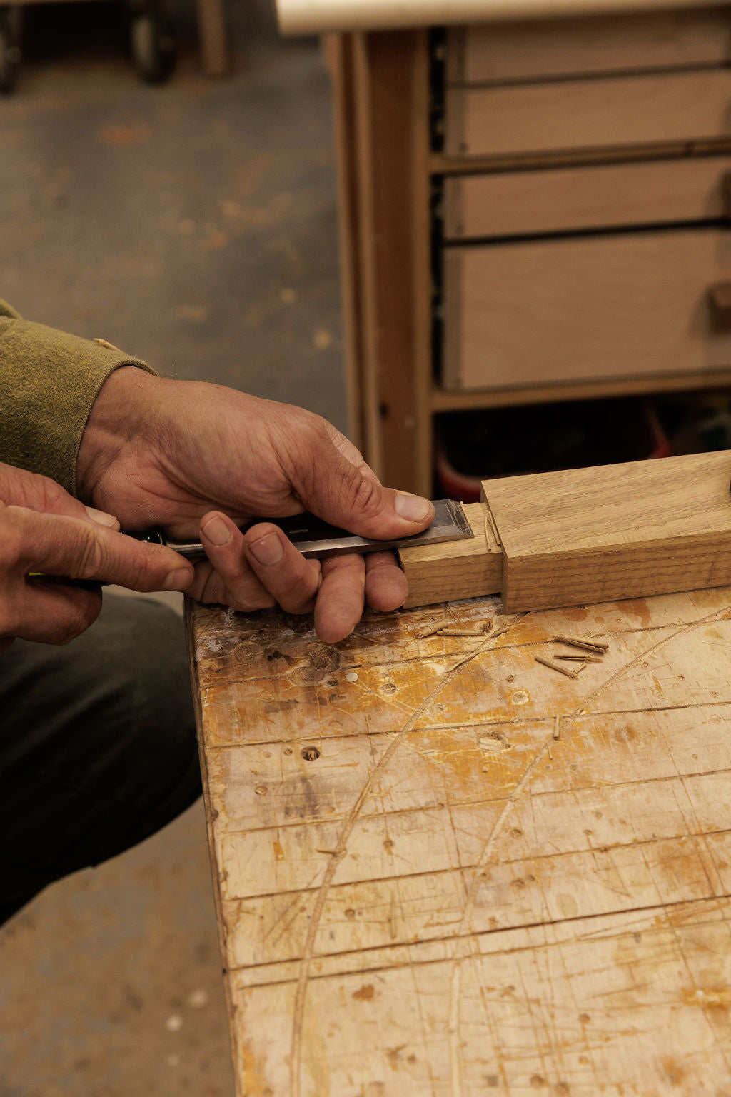 Hands carving a piece of wood for joinery