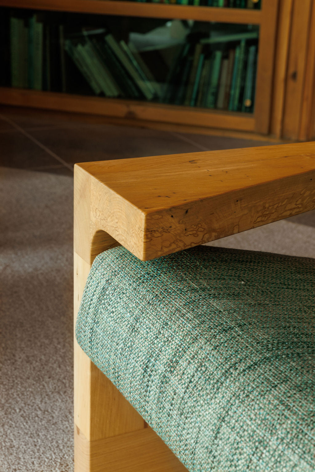 A close detail shot of a custom arm chair. Showcasing the angular arm rest and the texture of the fabric.