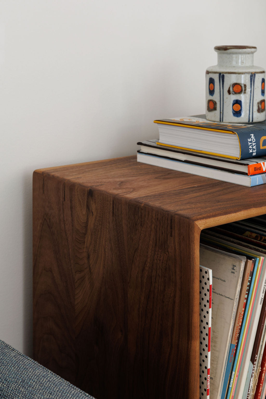 A close detail shot of a dark wood free standing cube shelf. Showcasing the wood grain and the corner join of the top and side of the shelf.