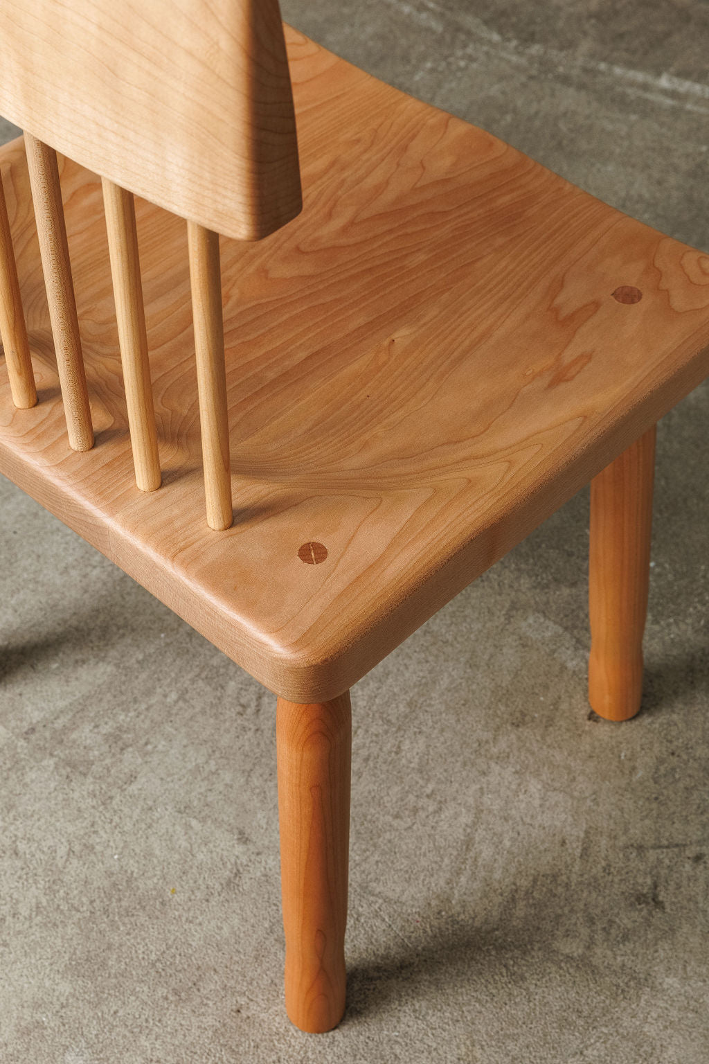 A light wood handmade modern minimal dining chair. Shot from the top to showcase the craftsmanship and grain of the wood.